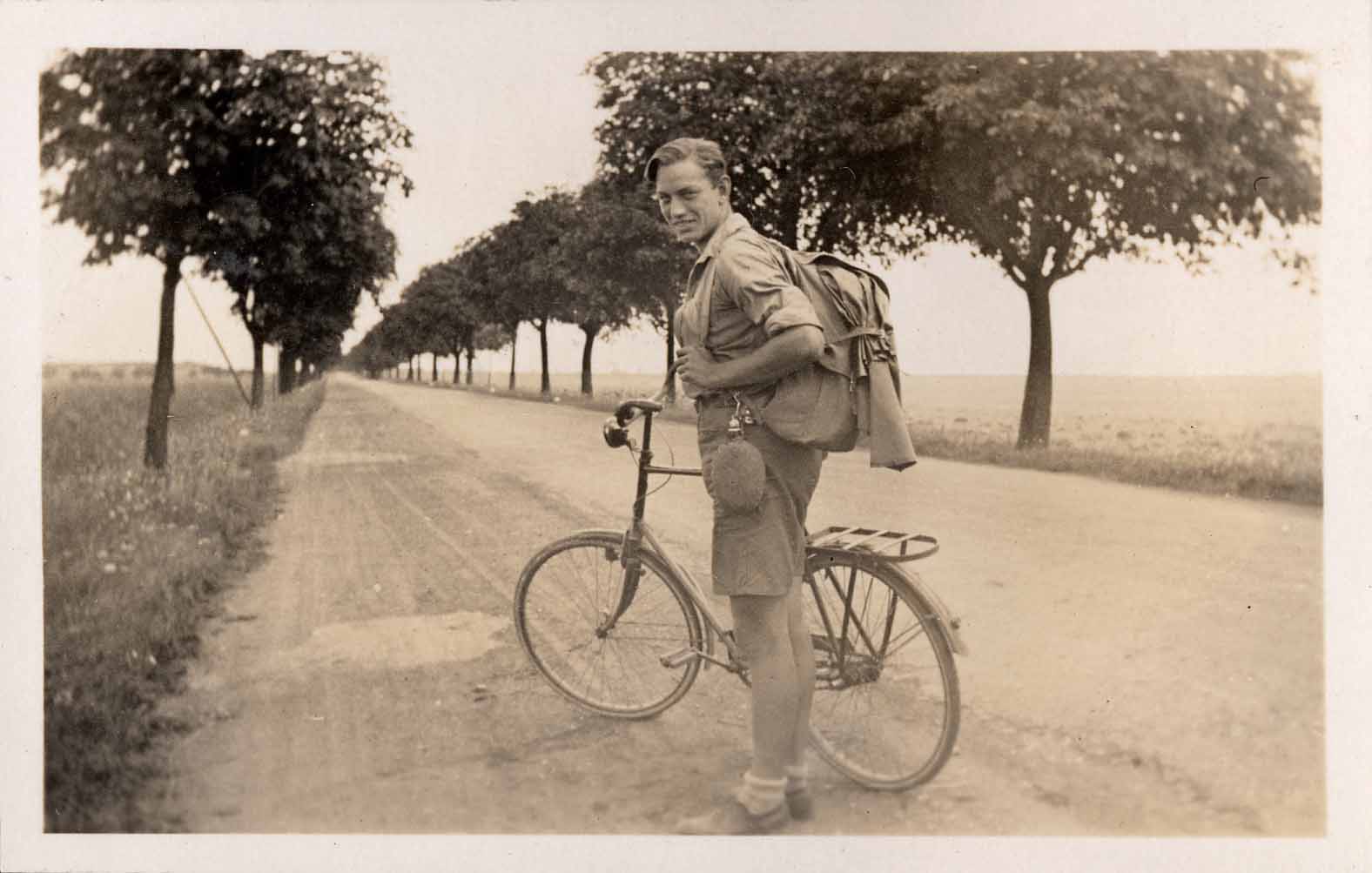 Old picture of a boy standing next to a bike