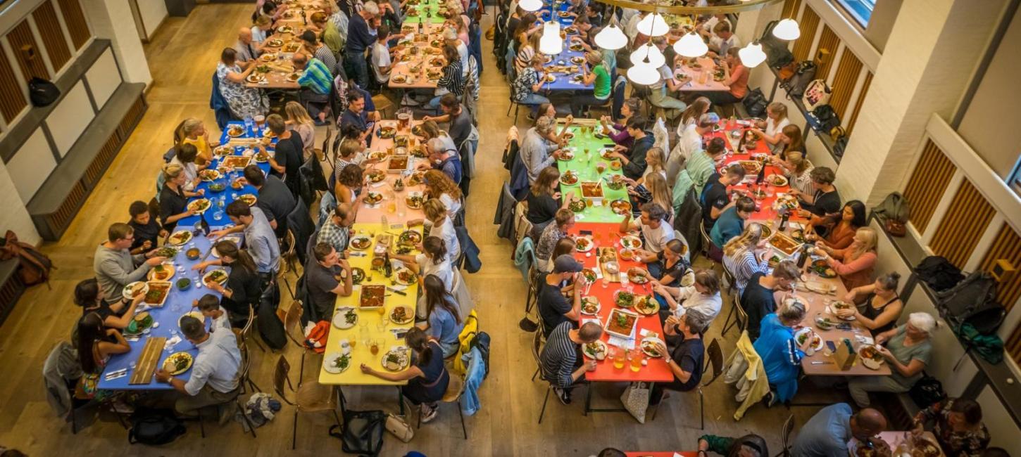 People sitting at rows of table having meals