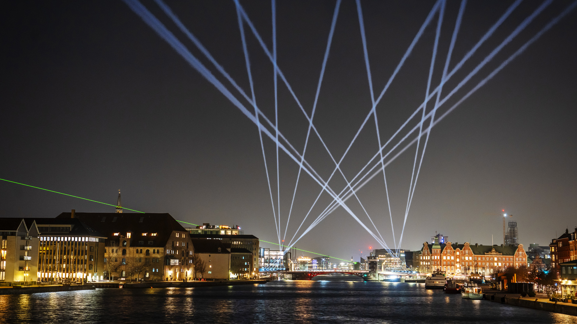 City at night with laser beams spread across the sky