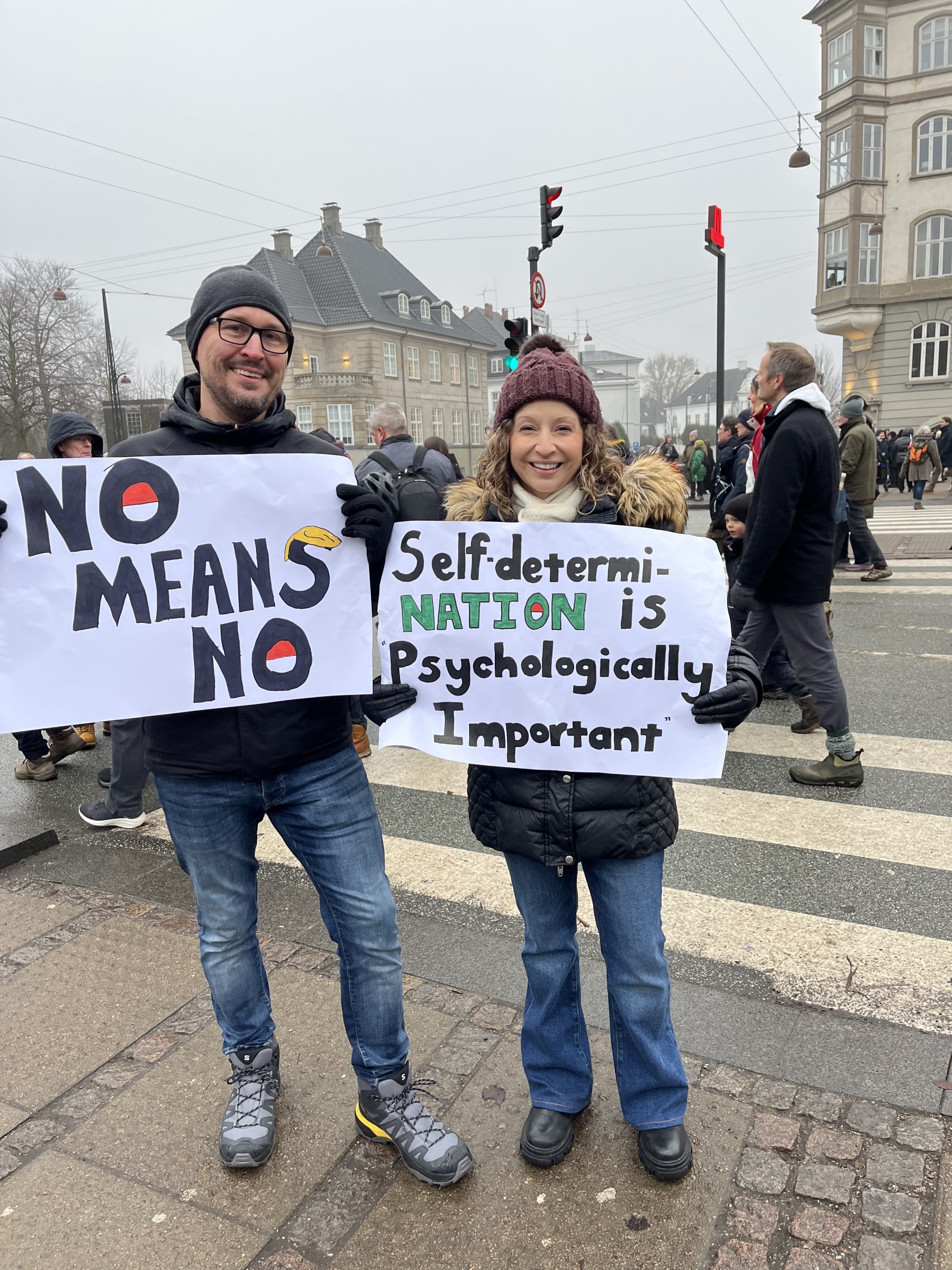 Two people standing with posters at a protest