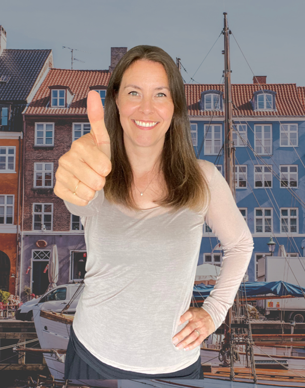 Portrait of a woman from waist up holding up a thumbs up
