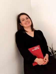 Daniela standing with a book 