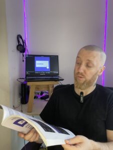 Liam sitting in his room with a book 